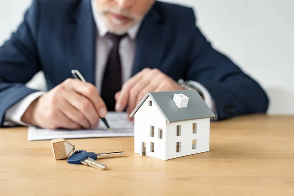 Enfoque selectivo del modelo de casa cerca de llaves y distribuidor de casa - foto de stock