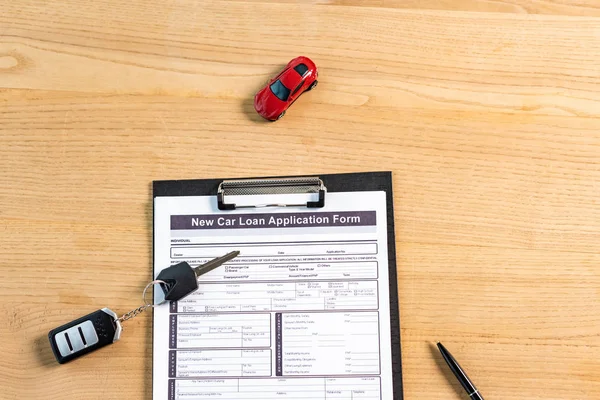 Vue du haut du presse-papiers avec document près du stylo, de la voiture jouet et de la clé de voiture — Photo de stock