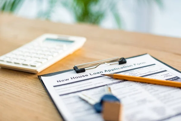 Selective focus of clipboard with document near pencil, keys and calculator — Stock Photo