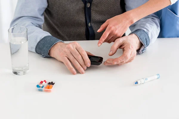 Ausgeschnittene Ansicht von Blutzuckermessgeräten in Menschenhänden — Stockfoto