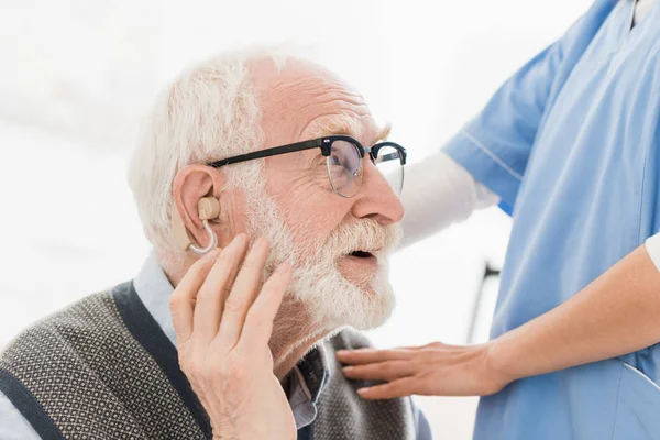 Profile of happy bearded man with hearing aid, looking away — Stock Photo