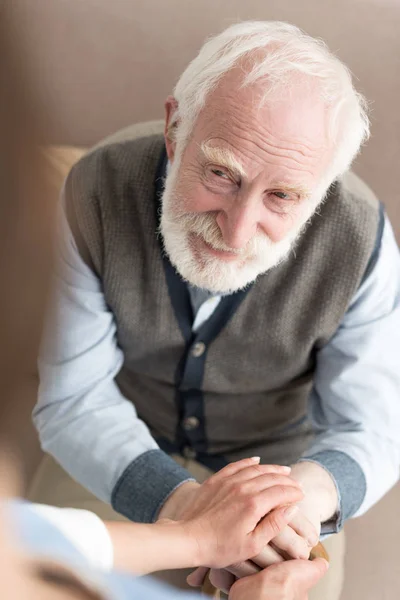 Blick aus der Vogelperspektive auf einen lächelnden älteren Mann, der Frauenhände hält — Stockfoto