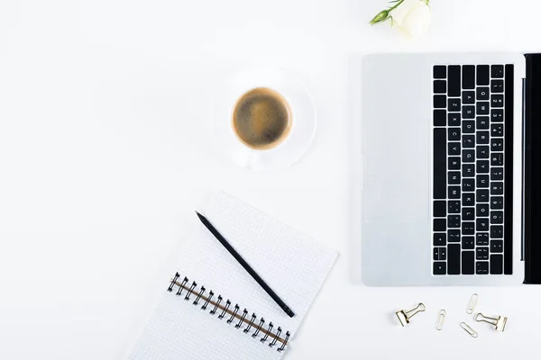 Верхний вид ноутбука, ноутбук с ручкой, скрепки, скрепки, цветок и чашка кофе на белом — стоковое фото