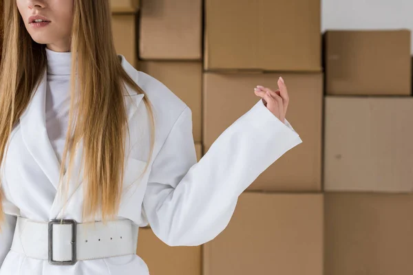 Cropped view of girl standing near brown cardboard boxes — Stock Photo