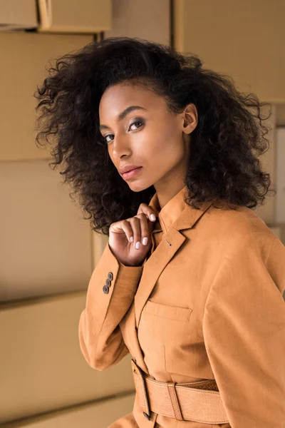 Attractive african american girl looking at camera near carton boxes — Stock Photo