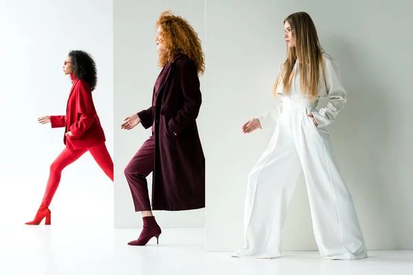 Jolies femmes blondes et rousses posant près de belle fille afro-américaine sur blanc — Photo de stock