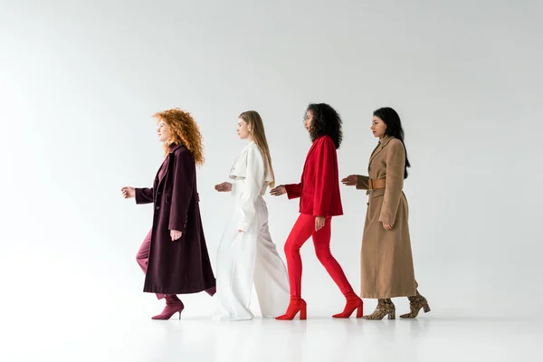 Jolies femmes blondes et rousses marchant avec des filles afro-américaines sur blanc — Photo de stock