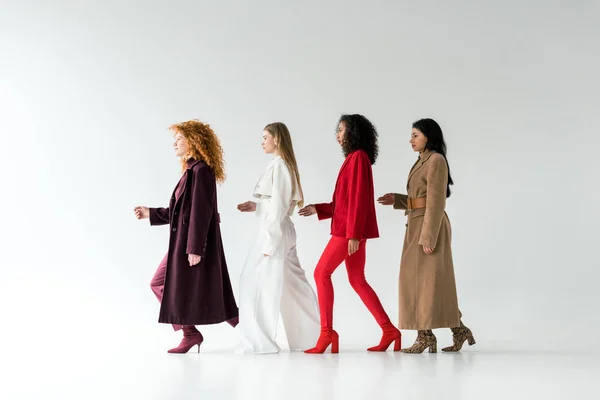 Pretty blonde and redhead women walking with african american girls on white — Stock Photo