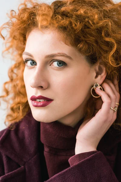 Close up de mulher ruiva encaracolado atraente olhando para a câmera e tocando o cabelo — Fotografia de Stock
