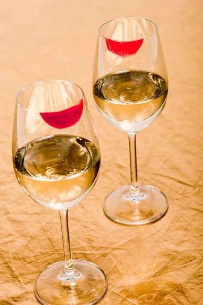 Lápiz labial rojo en copas de champán con alcohol en naranja - foto de stock