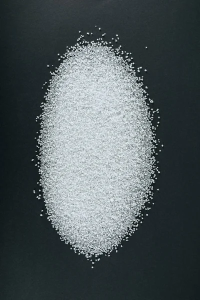 Вид кристаллов сладкого белого сахара на черном фоне — стоковое фото