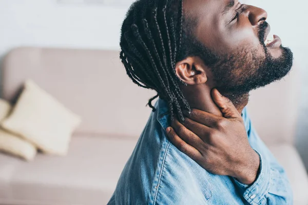 Bel homme afro-américain souffrant de douleurs au cou avec les yeux fermés — Photo de stock