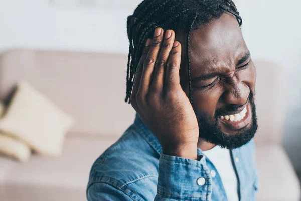 Handsome african american man suffering from headache with closed eyes — Stock Photo