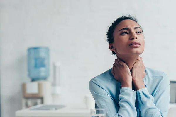 Jolie femme d'affaires afro-américaine souffrant de douleurs au cou au bureau — Photo de stock