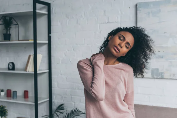 Mulher afro-americana exausta que sofre de dor no pescoço com os olhos fechados — Fotografia de Stock