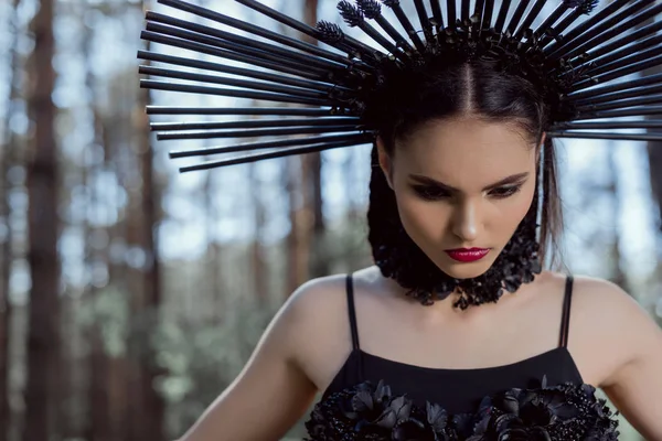 Retrato de mulher bonita em traje de bruxa em pé no fundo da floresta — Fotografia de Stock