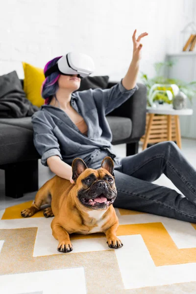 Cane vicino ragazza con capelli colorati e VR auricolare seduto sul pavimento — Foto stock