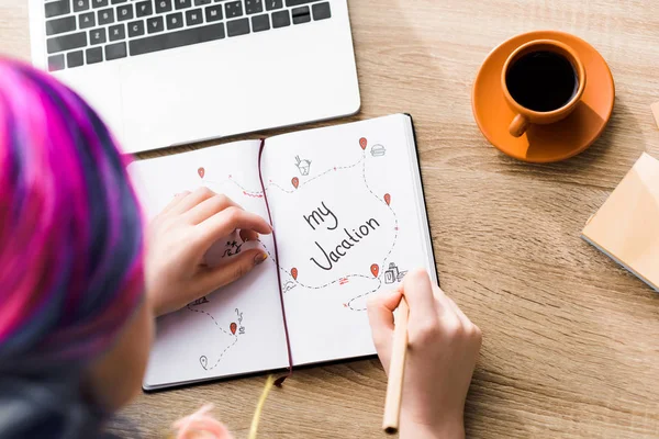 Selective focus of girl with colorful hair writing notes in notebook — Stock Photo
