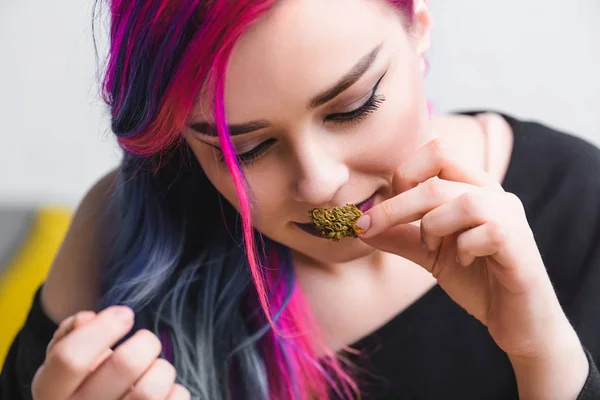 Menina hipster com cabelo colorido farejando maconha medicinal — Fotografia de Stock