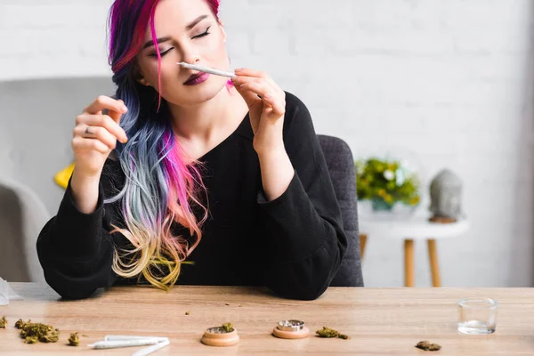 Belle fille hipster avec cheveux colorés renifler joint avec de l'herbe — Photo de stock