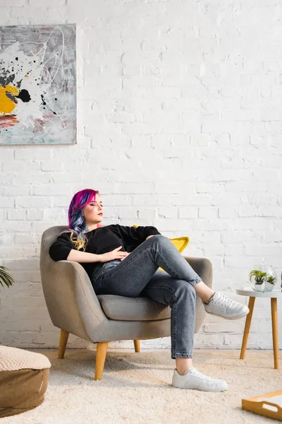 Хипстерская девушка в повседневной одежде отдыхает на кресле дома — стоковое фото