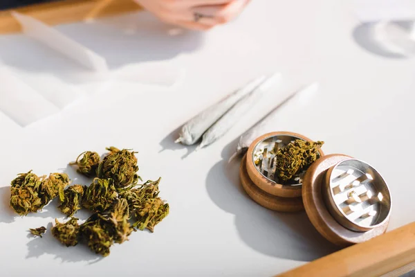 Close up view of medical marijuana, joints and herb grinder — Stock Photo