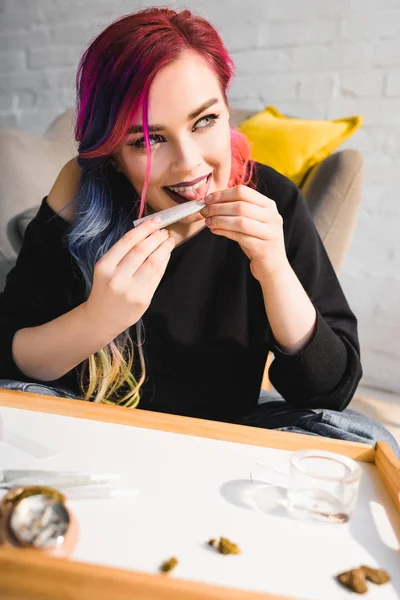 Bela hipster menina lambendo conjunta, sorrindo e olhando para longe — Fotografia de Stock