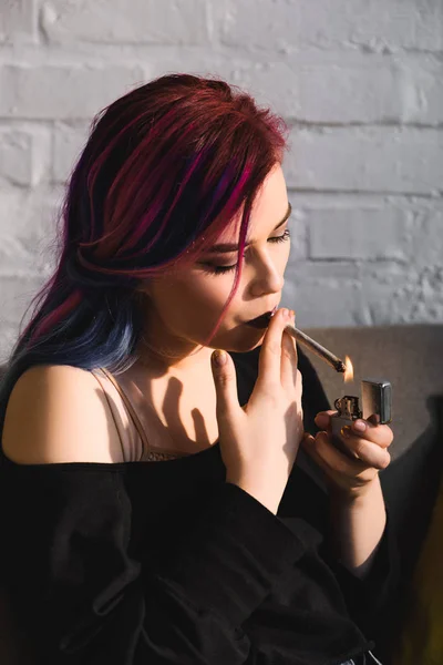 Beautiful hipster girl lighting up and smoking joint with medical marijuana — Stock Photo