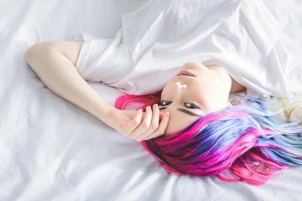Vista superior da menina atraente deitado na cama e olhando para a câmera — Fotografia de Stock