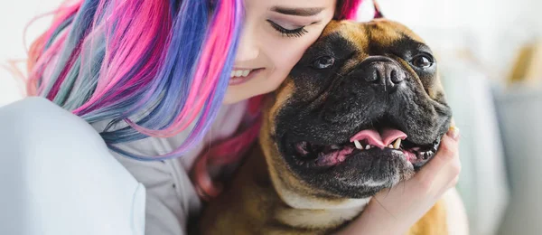 Plan panoramique de fille avec cheveux colorés câlins avec bulldog français — Photo de stock