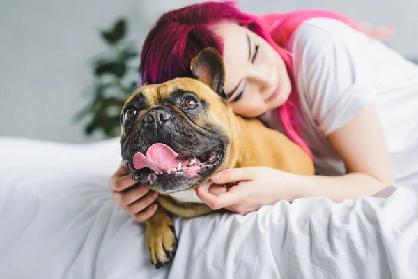 Messa a fuoco selettiva di bella ragazza con i capelli colorati abbracciando carino bulldog — Foto stock