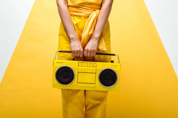 Vista cortada da mulher posando com boombox retro em branco e amarelo — Stock Photo