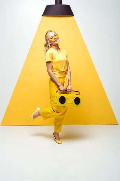 Allegra donna in posa con boombox retrò su bianco e giallo — Foto stock