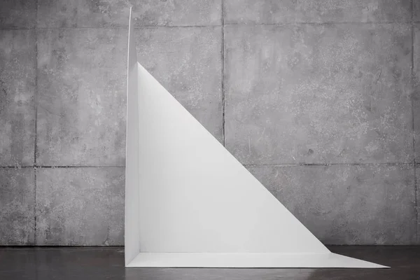 Triangle shape carton near grey wall with copy space — Stock Photo