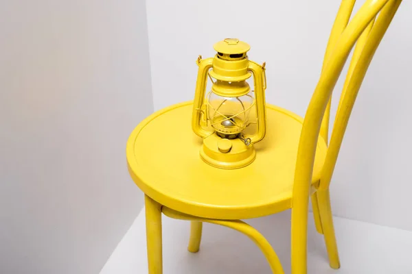 Винтажная лампа на желтом и удобном кресле на белом — стоковое фото