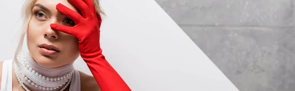 Panoramic shot of stylish woman in red glove covering face on white and grey — Stock Photo