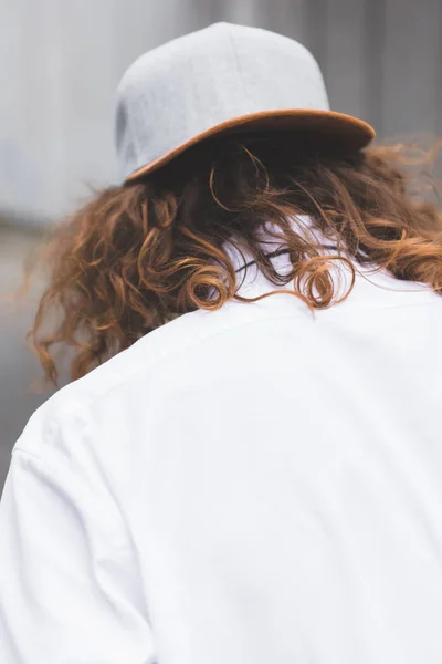 Vista posterior del hombre con el pelo rizado en taza y camisa blanca - foto de stock