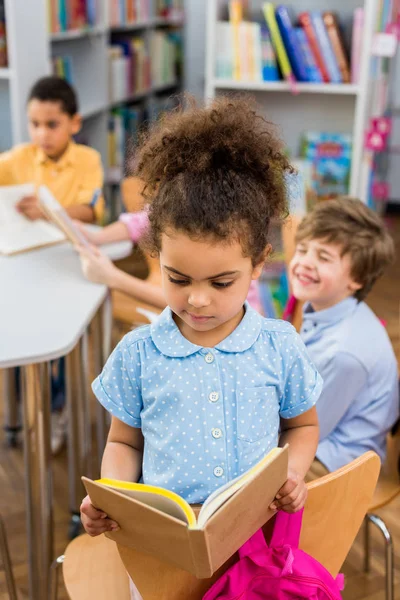 Focus selettivo del libro di lettura per bambini africani americani in biblioteca — Foto stock