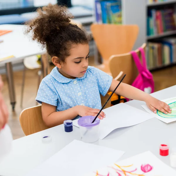 Messa a fuoco selettiva di carino bambino africano americano toccare la carta con la pittura — Foto stock