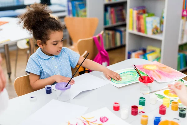 Enfoque selectivo del niño afroamericano tocando papel con dibujo - foto de stock