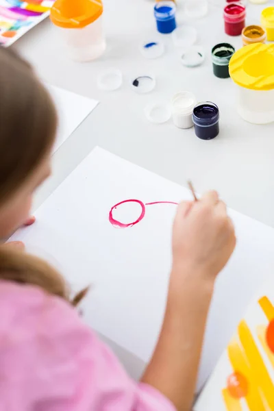 Cropped view of kid painting on paper with red gouache paint — Stock Photo