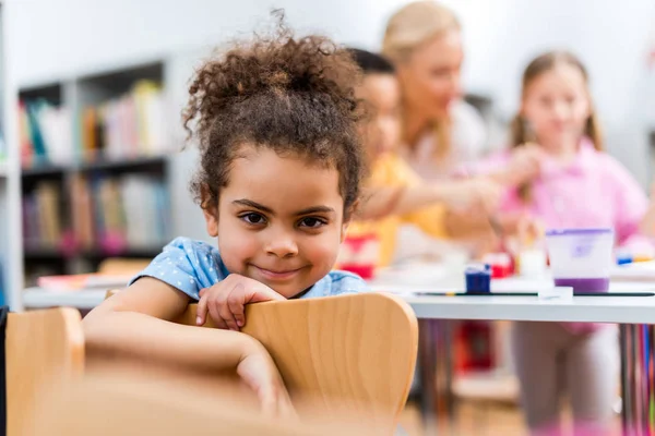 Selektiver Fokus eines glücklichen afrikanisch-amerikanischen Kindes, das in die Kamera blickt — Stockfoto