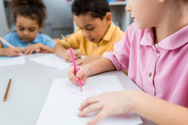 Messa a fuoco selettiva del bambino che disegna vicino ai bambini africani americani carini — Foto stock