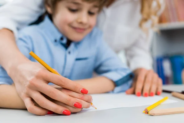 Selective focus of woman drawing with happy kid — Stock Photo