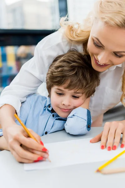 Selective focus of happy woman drawing with cute kid — Stock Photo