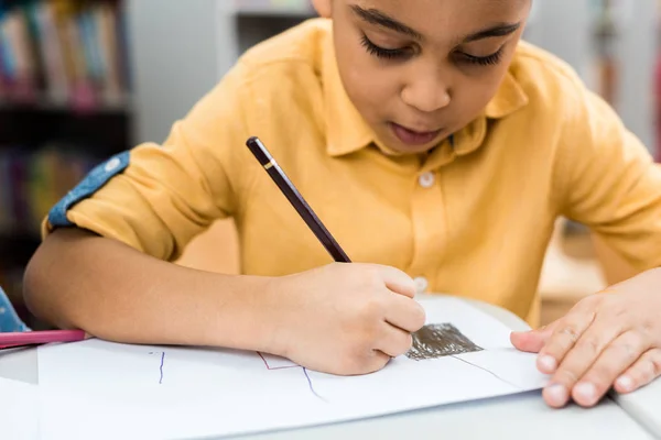 Selective focus of cute african american kid drawing with pencil — Stock Photo