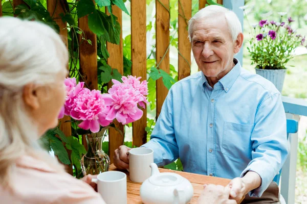 Selective focus of happy senior man holding hands with wife — Stock Photo