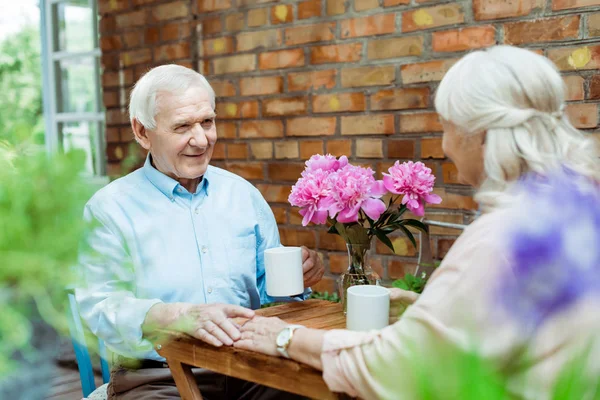 Selective focus of senior man touching hand of retired woman — Stock Photo