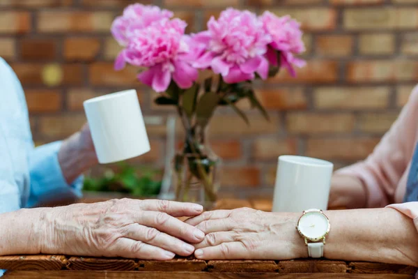 Vue recadrée de l'homme âgé touchant la main de la femme retraitée — Photo de stock