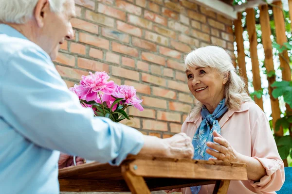 Tiefansicht einer fröhlichen Seniorin, die auf ihren Mann im Ruhestand blickt — Stockfoto